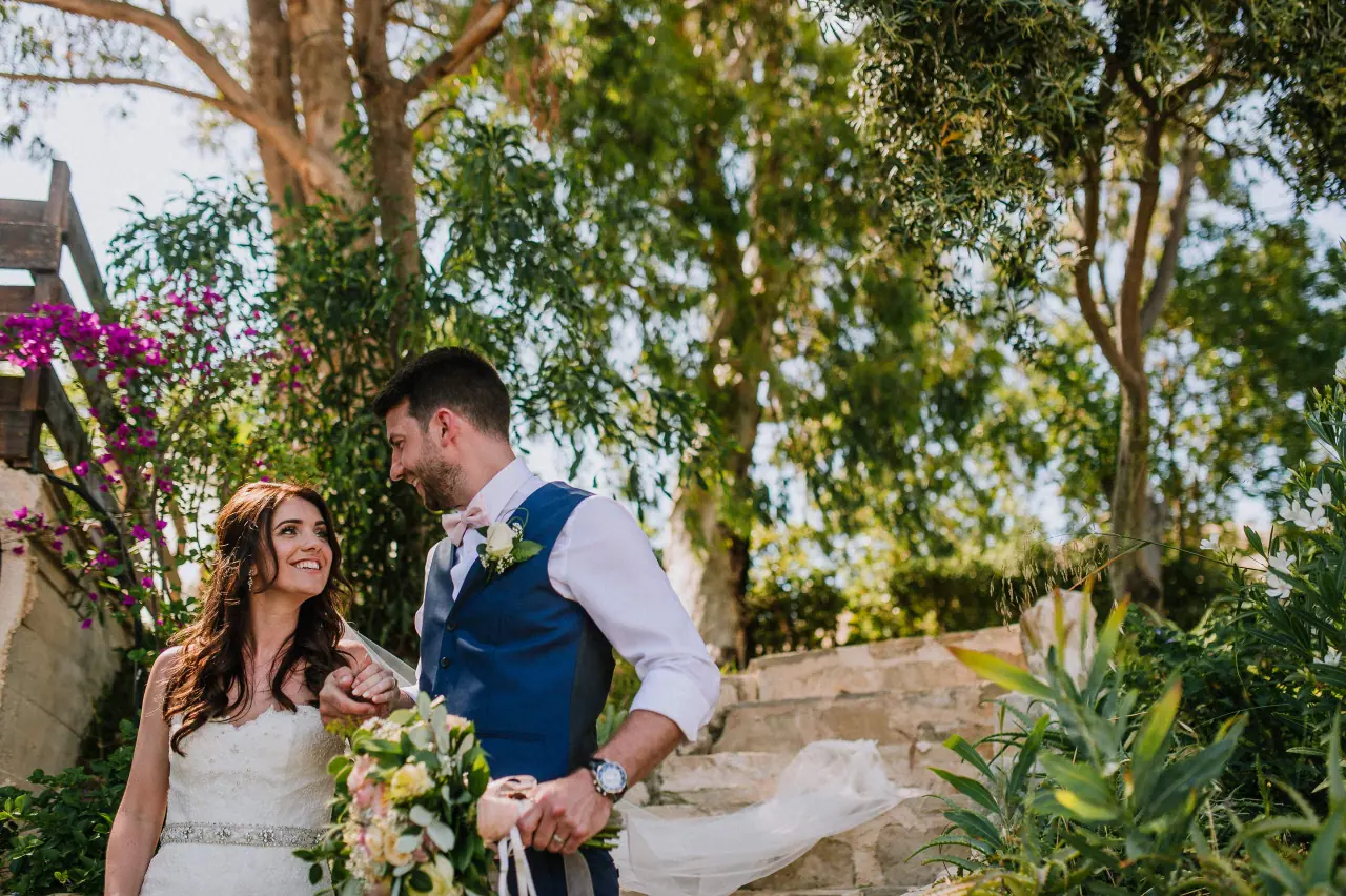 Claire and Sean among green trees and bougainvillea at Vasilias Nikoklis Inn, Paphos