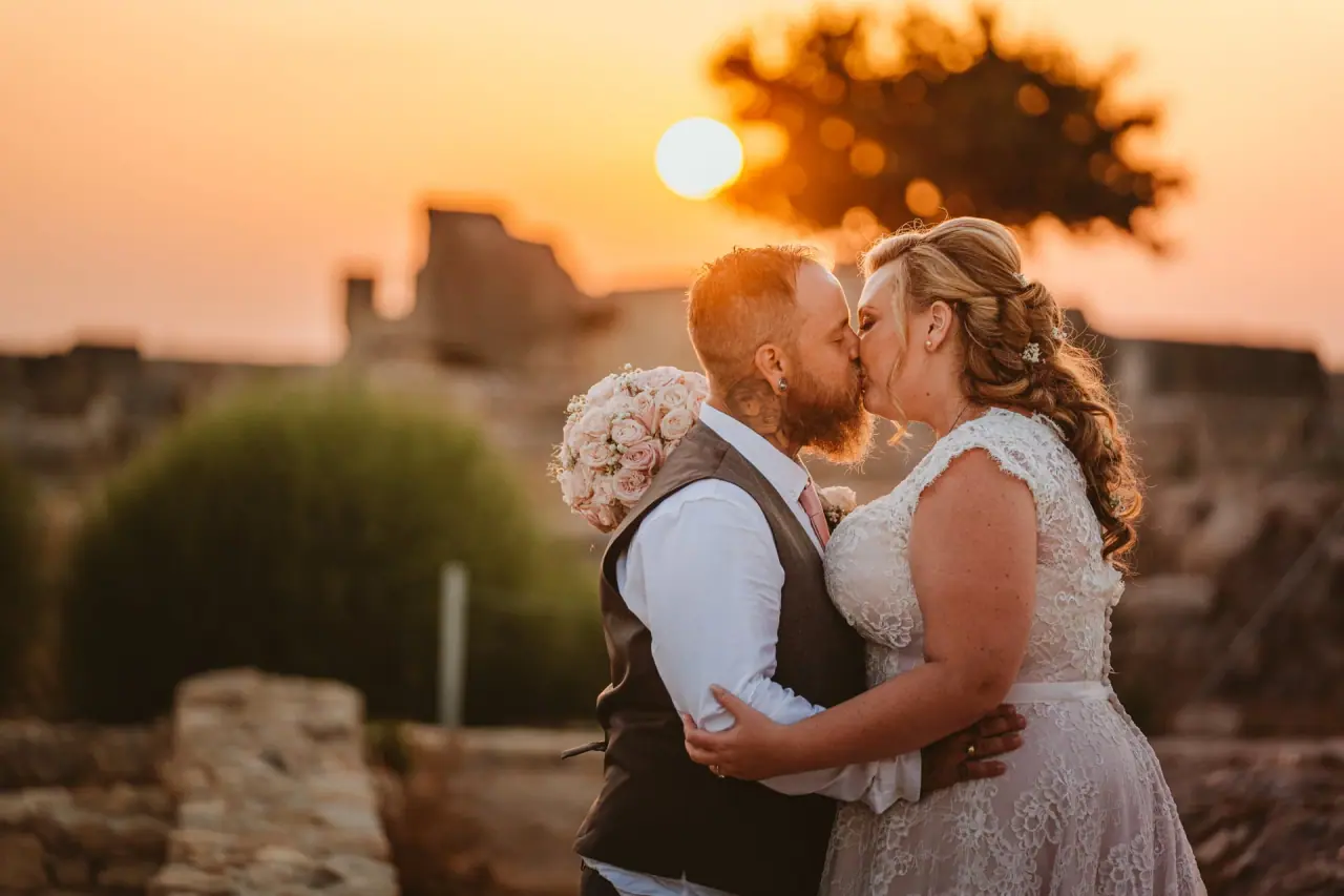 Jess and Andy kissing at sunset among stone ruins at Liopetro, Kouklia, Paphos