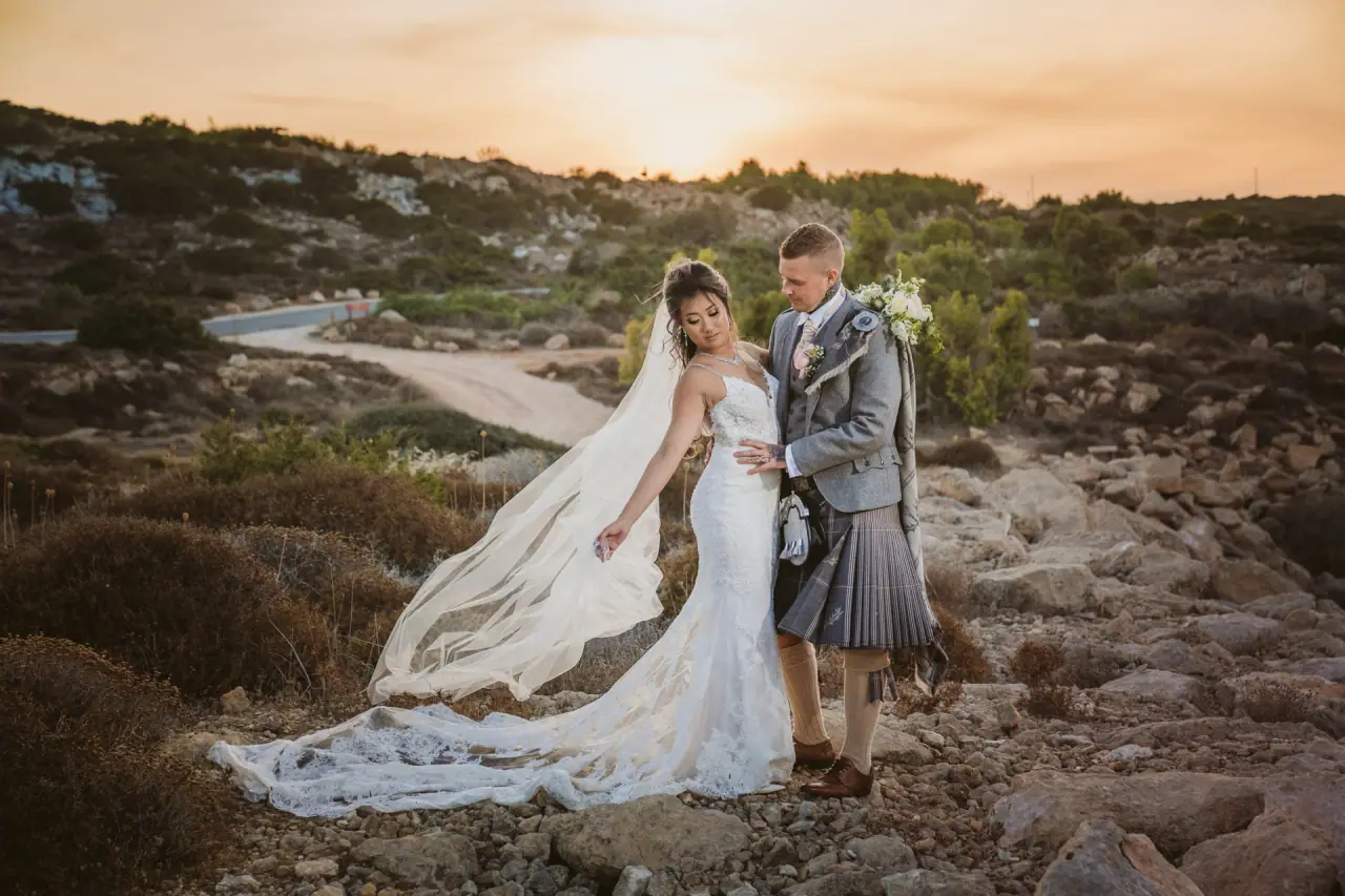 Kitty and Kevin, he in a kilt, on a rocky hillside at sunset near Olympic Lagoon, Ayia Napa