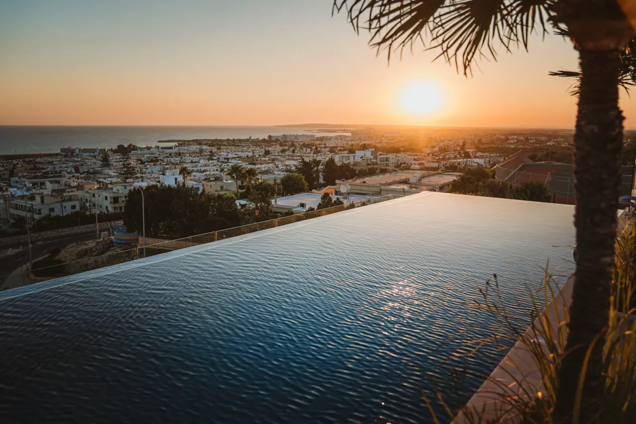 Infinity pool at Napa Suites at sunset, looking out over the rooftops of Ayia Napa to the sea