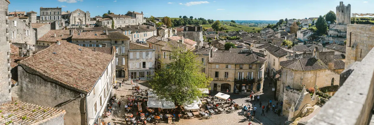Panoramic view over terracotta rooftops and stone buildings of a medieval town near Bordeaux, France