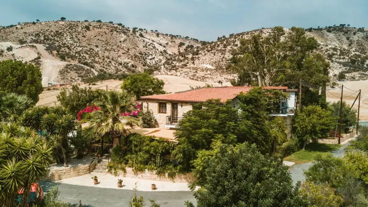 Aerial view of Vasilias Nikoklis Inn nestled among trees in the hills near Nikokleia