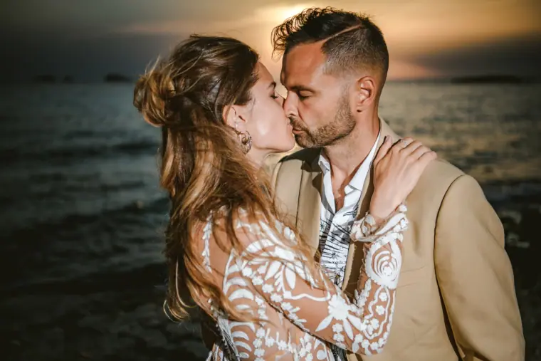 Close-up of Kenton and Hassiba kissing by the sea at golden hour, Ibiza