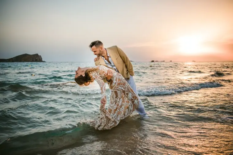 Kenton and Hassiba in a dramatic dip kiss among the waves at sunset, Ibiza