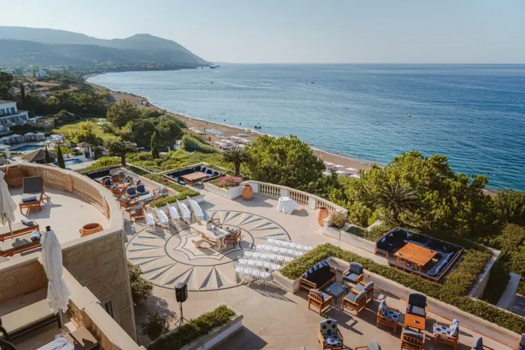 Elevated view of the Anassa Hotel terrace set for a ceremony above the beach and sea