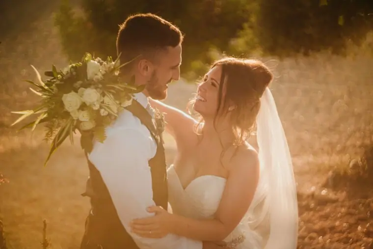 Hannah smiling up at Keith as he holds her close in warm sunset light