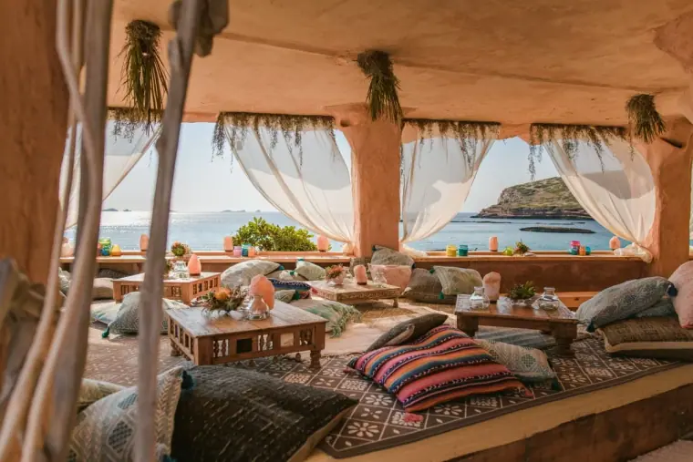 Draped boho lounge with cushions and rugs overlooking the sea at Sunset Ashram, Cala Conta