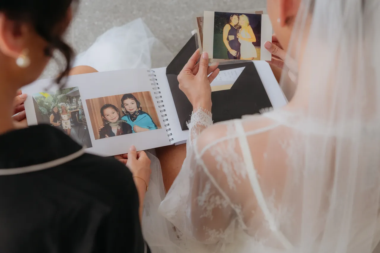 Bride turning the pages of a photo album gift from her bridesmaids