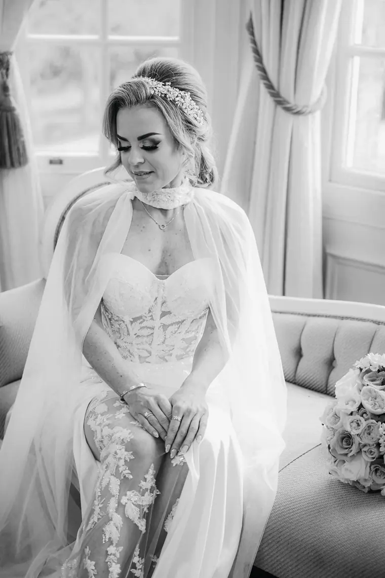 Black-and-white portrait of Jade seated in her caped gown and hair vine