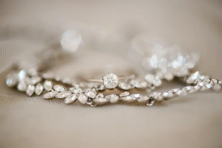 Sparkling crystal bridal hair vine and earrings laid out on a soft surface