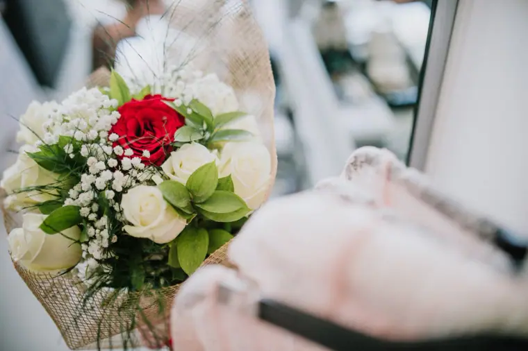 Bouquet of white and red roses with gypsophila beside a robe