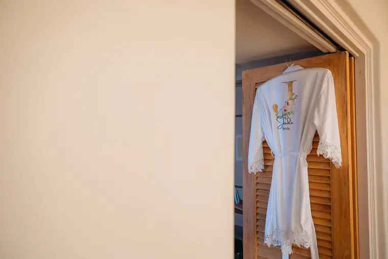 Bride's embroidered robe hanging on a wooden door