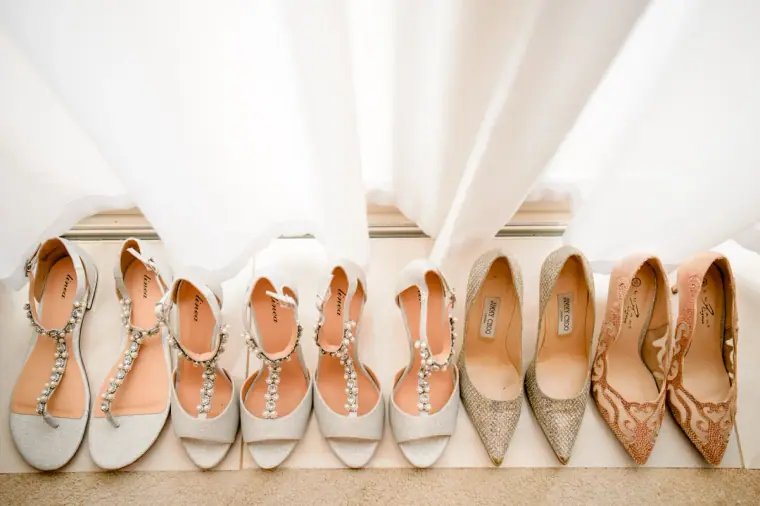 Row of rose-gold sandals and glitter heels for the bride and bridesmaids