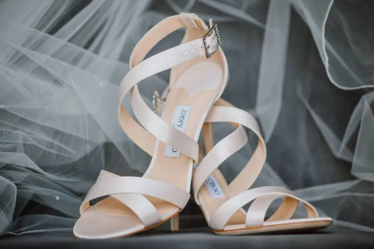 Ivory strappy wedding sandals resting on tulle