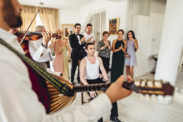 Lute player serenading Angelos as family watch the traditional groom's dressing