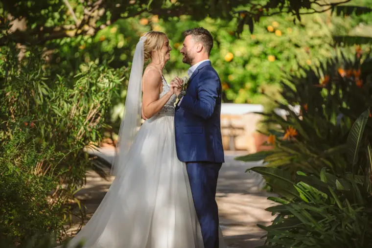 Sophie and Iain facing each other under trees in dappled sunlight