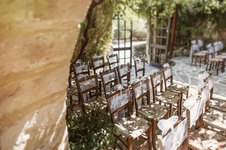 Rows of rush-seated wooden chairs set out for the ceremony in the inn's courtyard