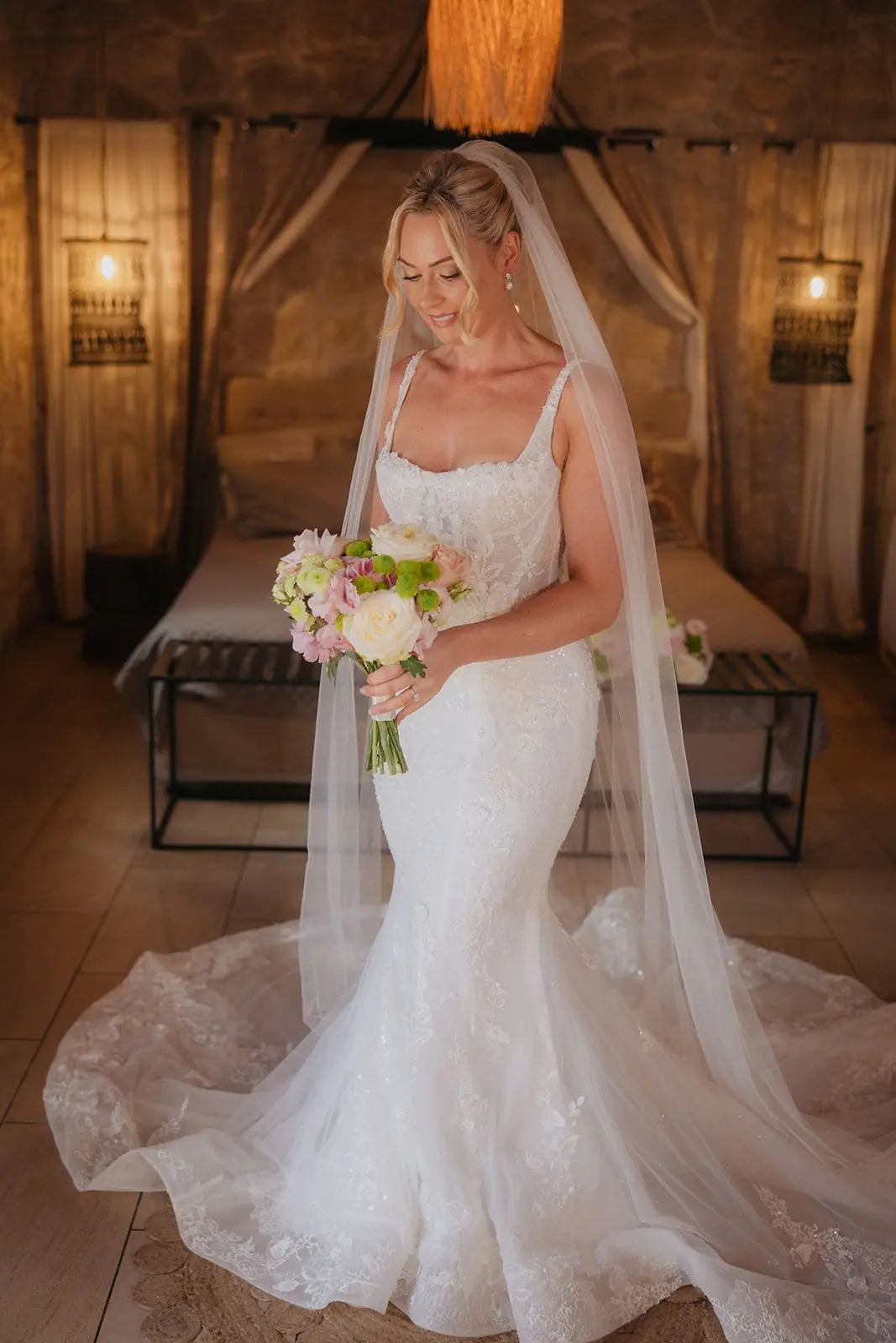 Bridal portrait of Zoe holding her bouquet, her veil falling to the floor