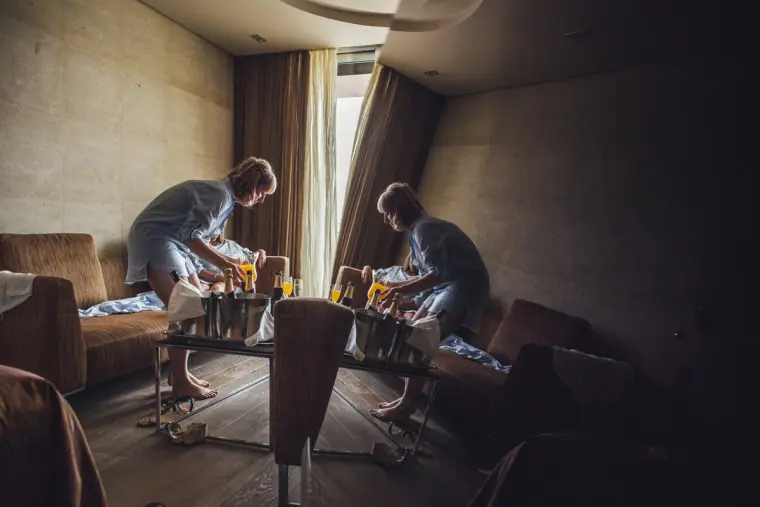 Bridesmaids getting ready in a dimly lit hotel room