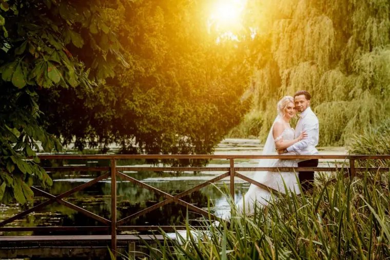 Abby and Taz on a wooden bridge beneath willows in golden light, Ardington House