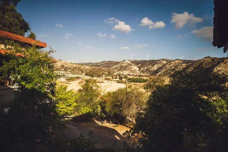 View across green trees to the rolling hills around Nikokleia