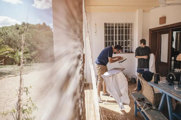 Groom and friends getting ready in a sunny villa doorway