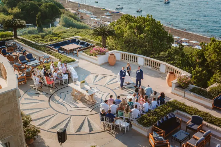 Overhead view of the ceremony on the mosaic terrace at Anassa Hotel, sea beyond