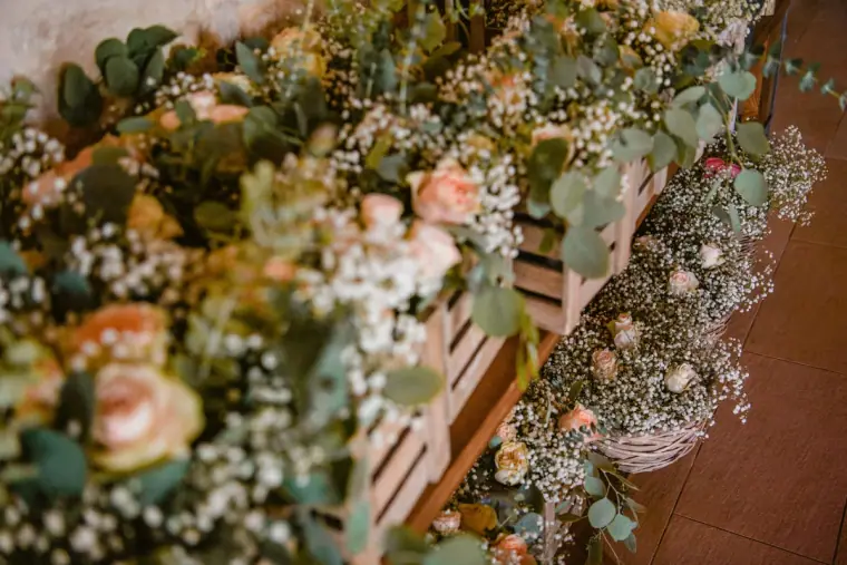 Pastel roses, eucalyptus and gypsophila arranged on a wooden ladder