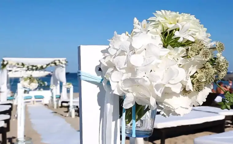 White hydrangea arrangement lining a beach ceremony aisle at Nassau Beach Club, Ibiza