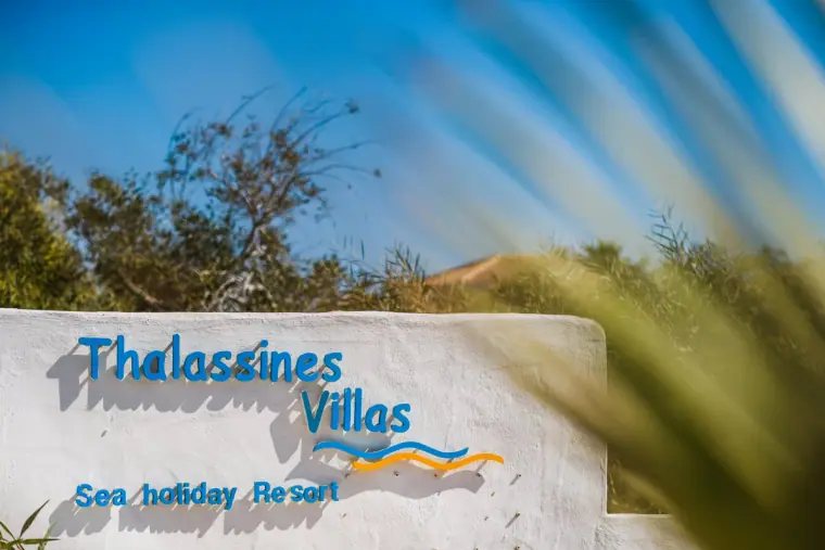 Thalassines Villas Sea Holiday Resort sign painted on a white wall