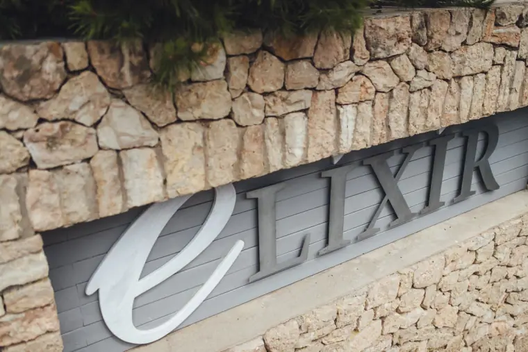 Elixir sign set into a dry-stone wall at Elixir Shore Club, Ibiza