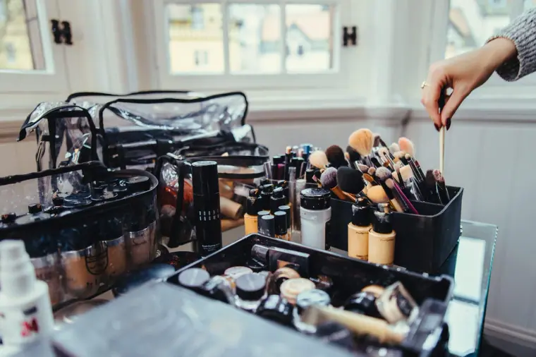 Make-up artist's brushes and foundations laid out by the window