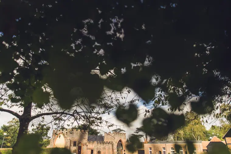 Historic house at Wasing Park glimpsed beneath overhanging leaves