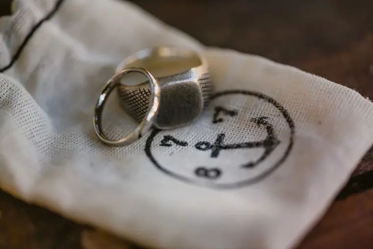 Signet ring and wedding band on a cotton pouch printed with an anchor
