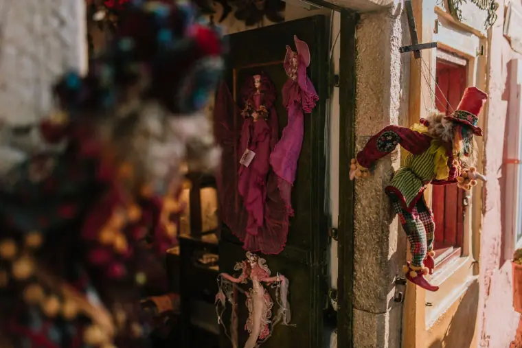 Dim shop doorway hung with puppets and colourful trinkets
