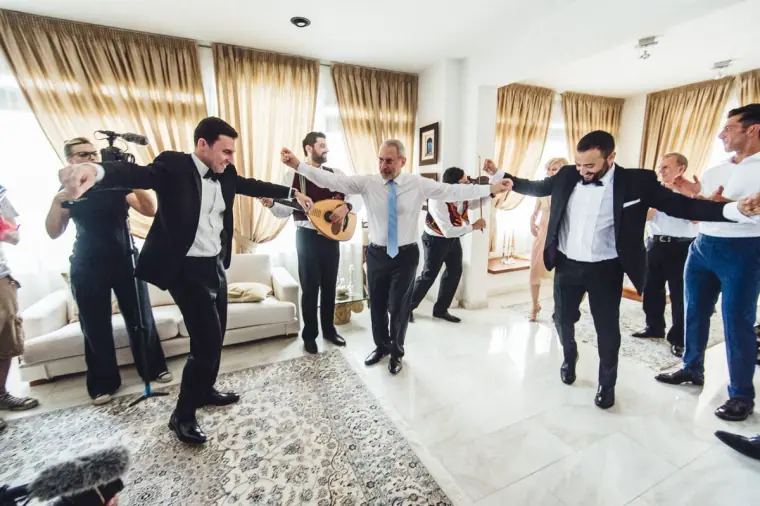 Angelos dancing a traditional Cypriot dance with family in the living room