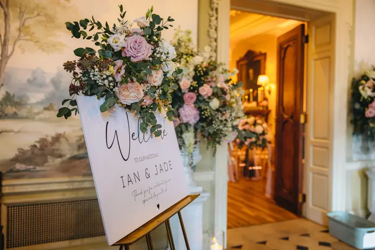 Welcome sign for Ian and Jade beneath a pink floral arrangement