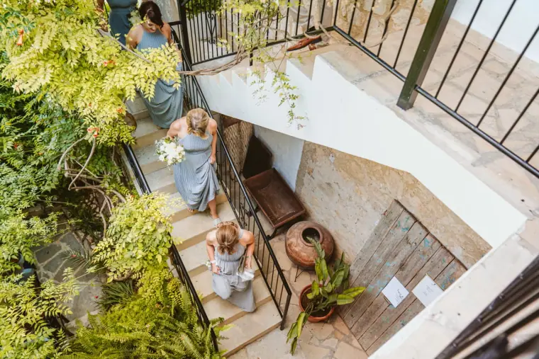 Bridesmaids in blue walking down the stone stairwell, seen from above