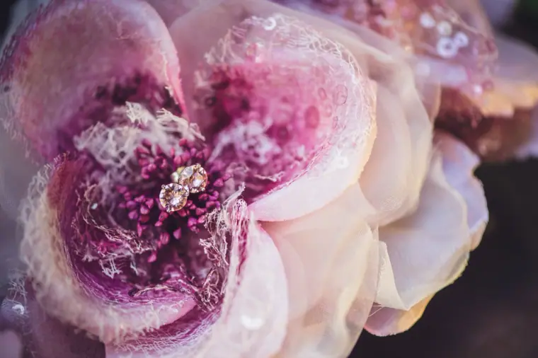 Diamond stud earrings nestled in the centre of a pink fabric flower
