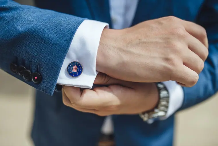 Close-up of the groom adjusting his cuff and cufflink