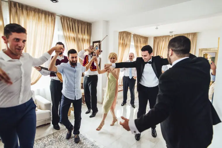 Family and friends dancing hand in hand around the groom