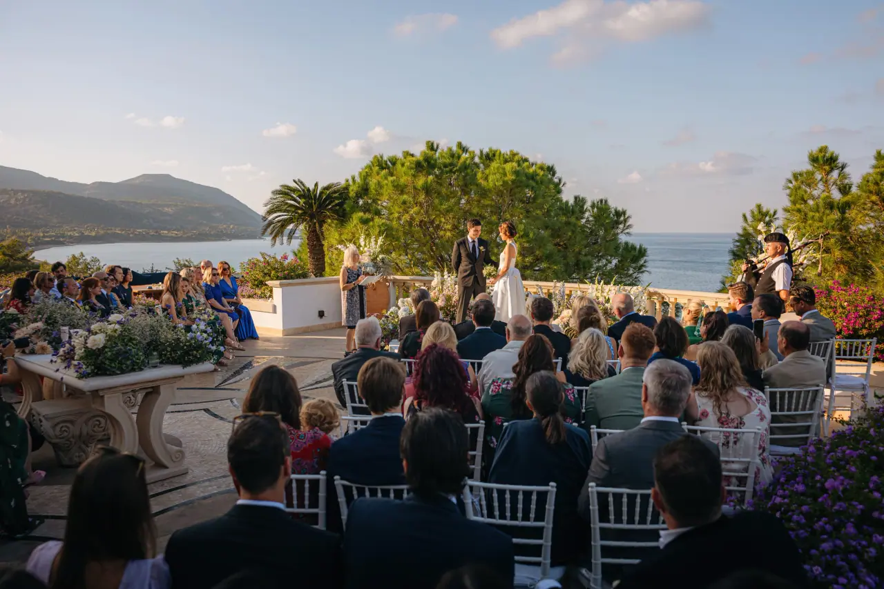 Guests seated for a clifftop ceremony overlooking the bay at Anassa
