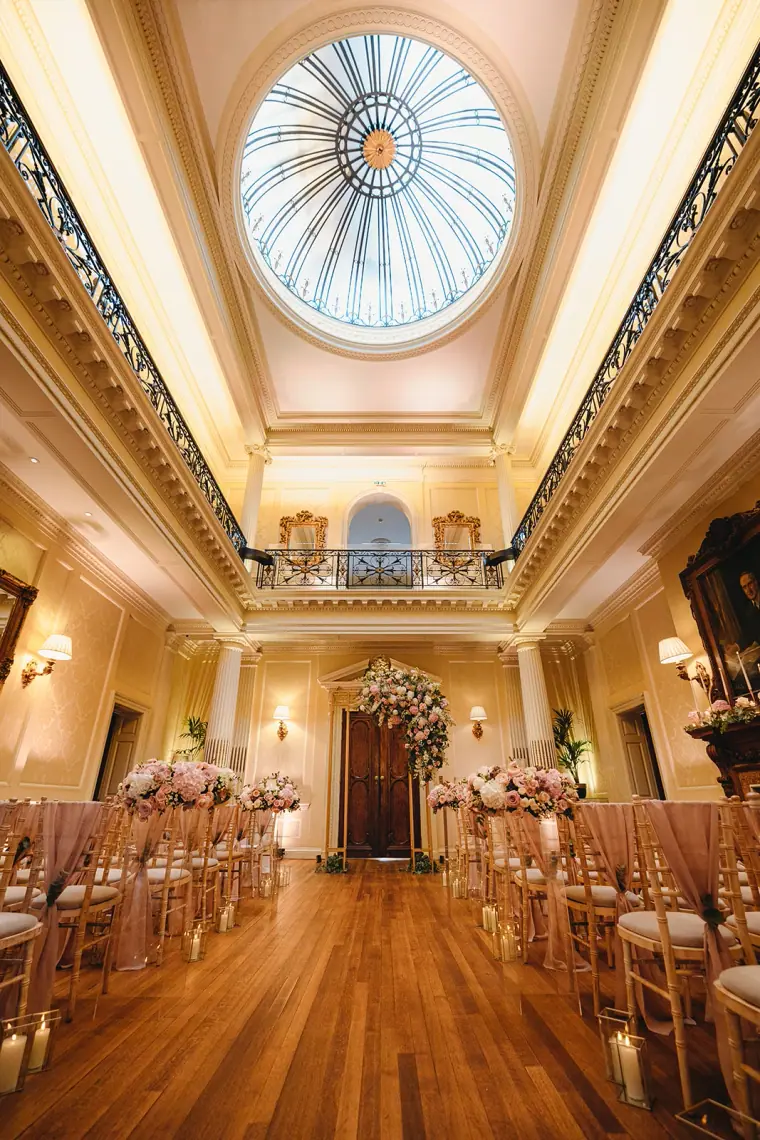 Ceremony room beneath an ornate domed skylight with rows of chairs
