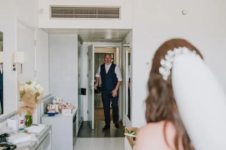 Claire's father arriving at the hotel room door as she waits in her veil