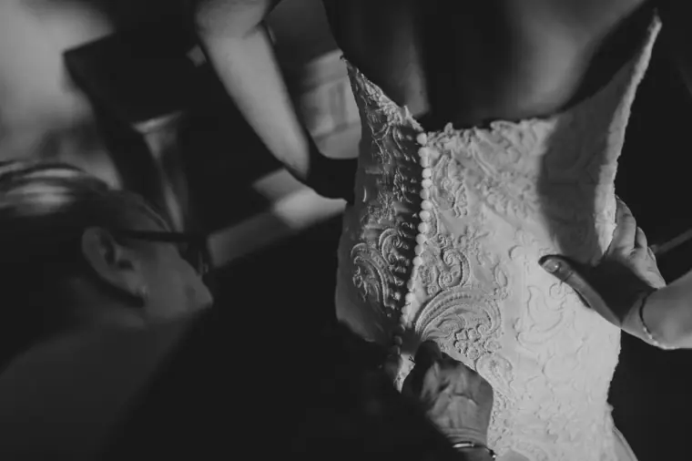 Black-and-white close-up of the buttoned lace back of the wedding dress