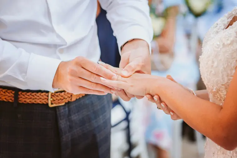 Close-up of the groom sliding the wedding ring onto the bride's finger