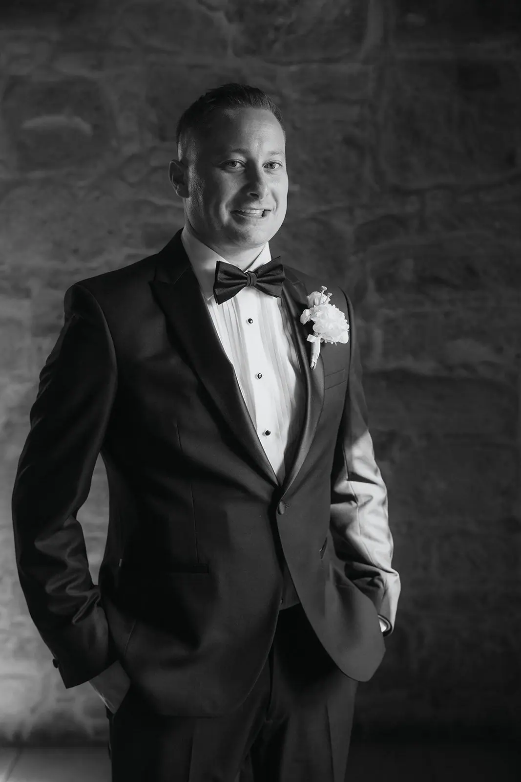 Black-and-white portrait of Oliver in his tuxedo, hand in pocket