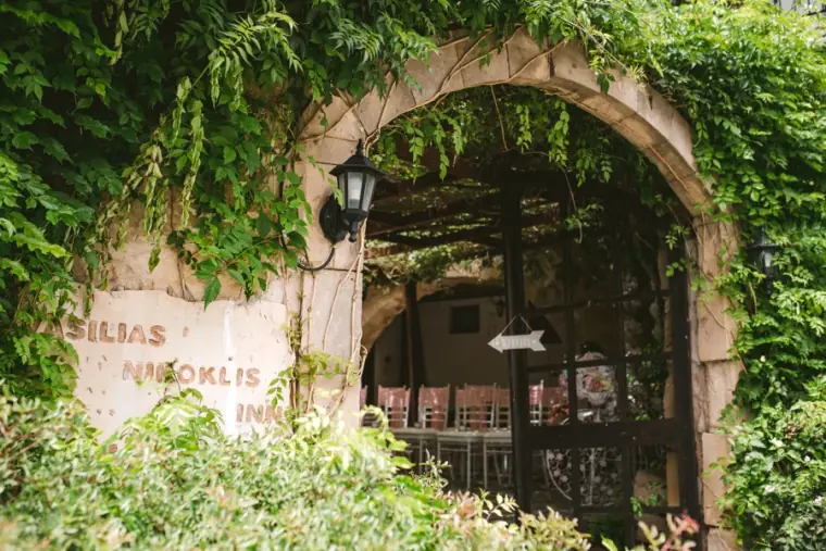 Ivy-covered stone archway entrance to Vasilias Nikoklis Inn