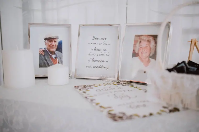 Memorial table with framed photos of loved ones and a candle