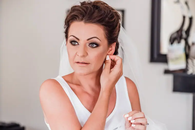 Bride putting in her earrings with her hair pinned up